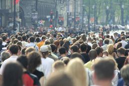 A back view of a dense crowd in a Downtown street. 